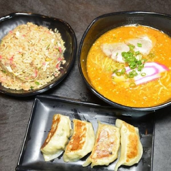 Daiichi Ramen's ramen bowl, fried rice, and gyoza dumplings on a dark table.